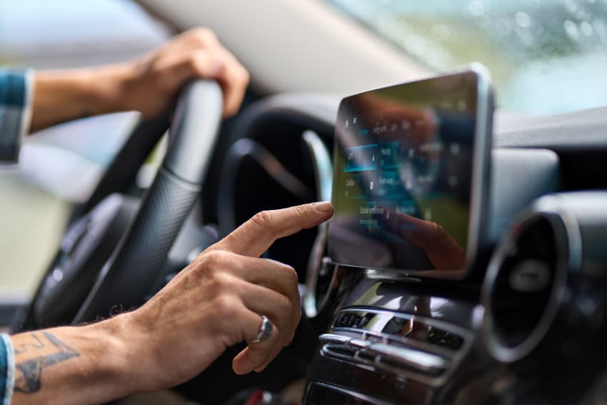 Close-up of driver using cars touchscreen entertainment system