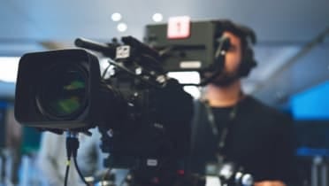 Production crew member using video camera