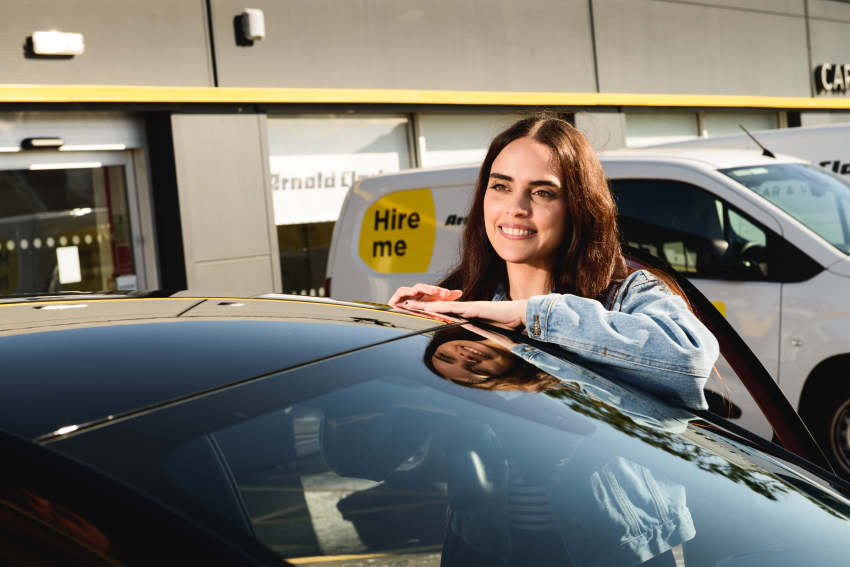 Customer at Arnold Clark Rental branch leaning by car
